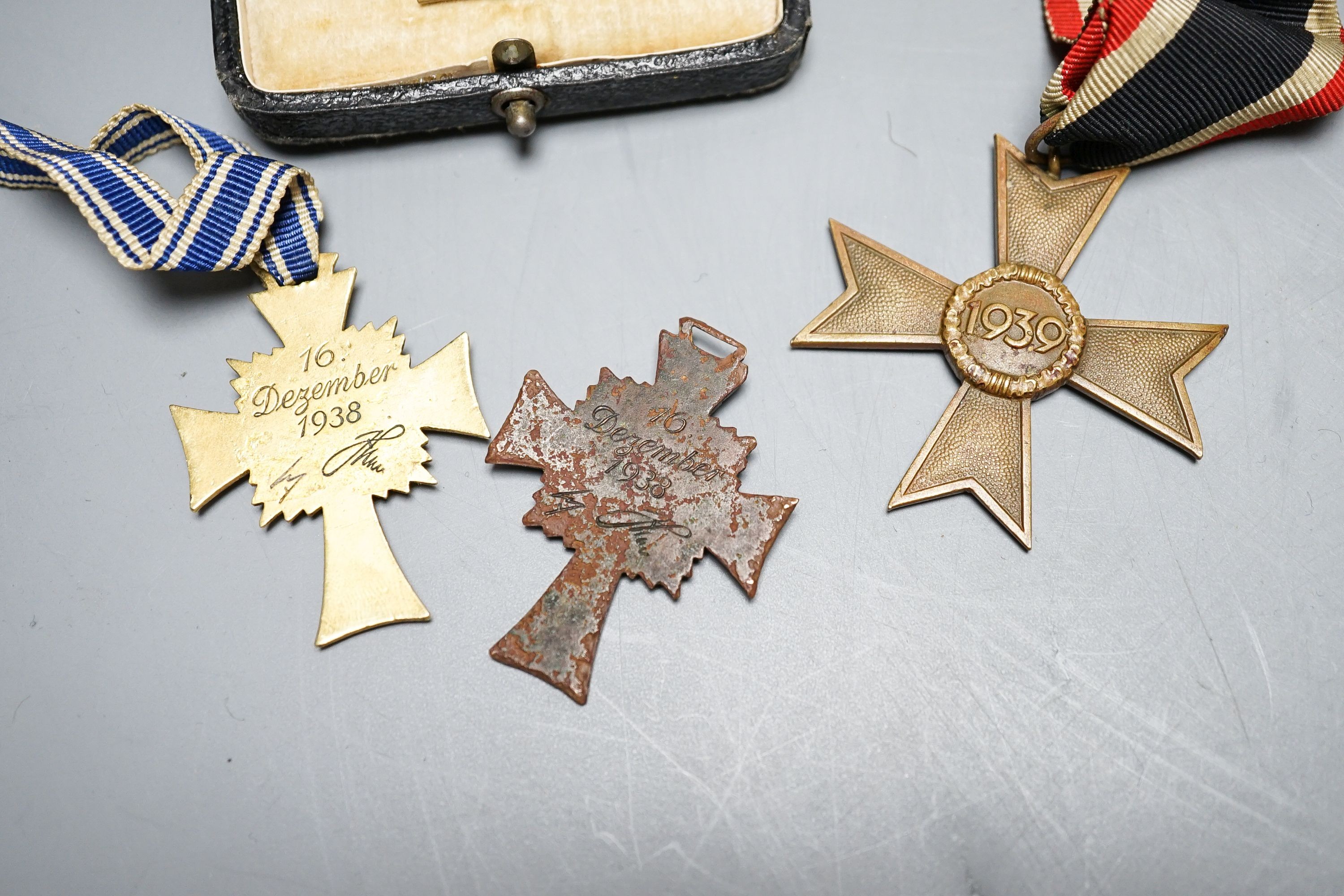 WWII Third Reich medals to include a Cross of Honour of the German Mother in gilt, another damaged in bronze, War Merit Cross (without swords), a 1939 Iron Cross and a Third Reich cuff link (5)